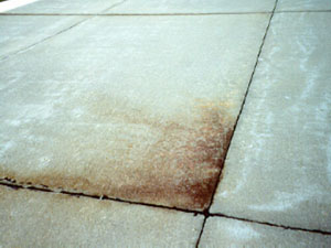 Overview photo of a slab corner where the pavement surface at the corner is discolored.  The discoloring (or staining)           of the surface is actually subgrade material that has been ejected from the subgrade due to pumping.