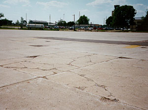 Overview photo showing a slab that is broken into more than five pieces.            The cracks that divide the pieces are a combination of medium- and high-severity cracks.