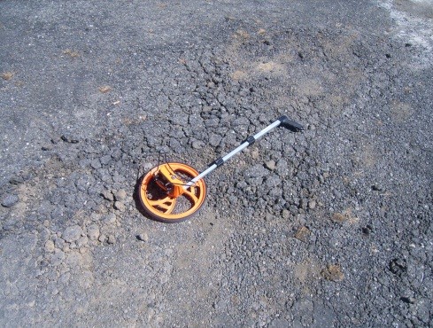 This picture shows a closeup photo of an asphalt pavement that is highly deteriorated with alligator cracking.  The PCI of the pavement in the image is 5.