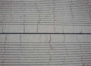 Close-up photo of a PCC joint with fine cracks perpendicular to the joint.            The cracks appear to be very tight with no visible signs of spalling.