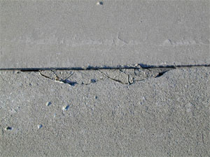 Close-up photo of a medium-severity joint spall.  The spall is broken into eight to ten pieces.